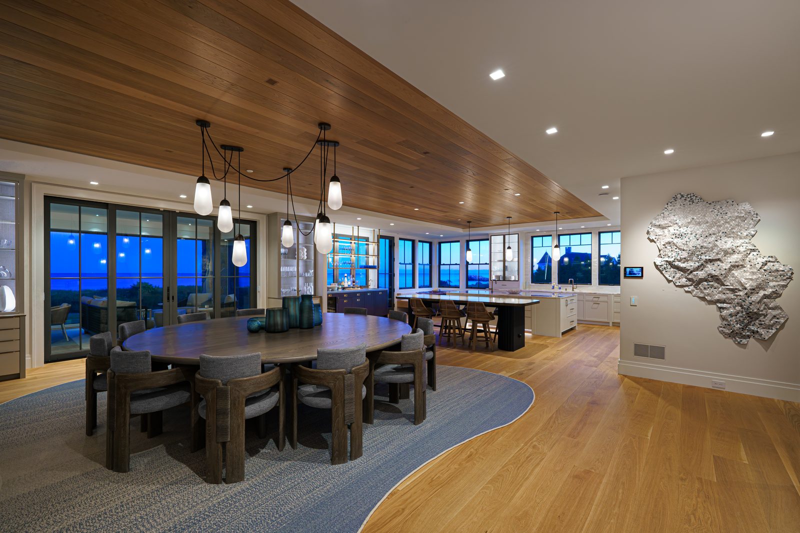 Luxury dining room with pendant lighting and ocean views controlled by Lutron HomeWorks
