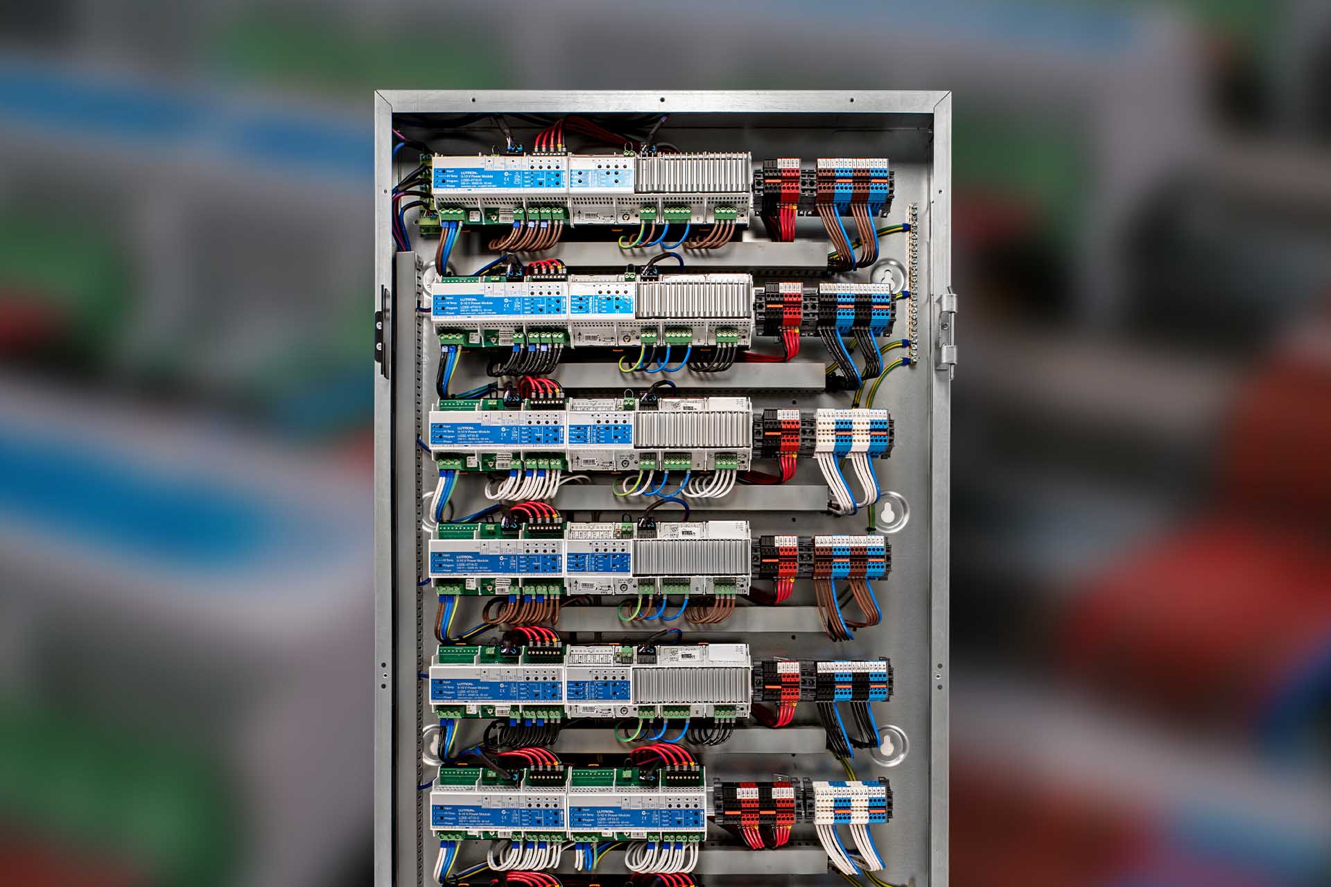 Lutron HomeWorks QSX lighting enclosure with organized modules and color-coded wiring
